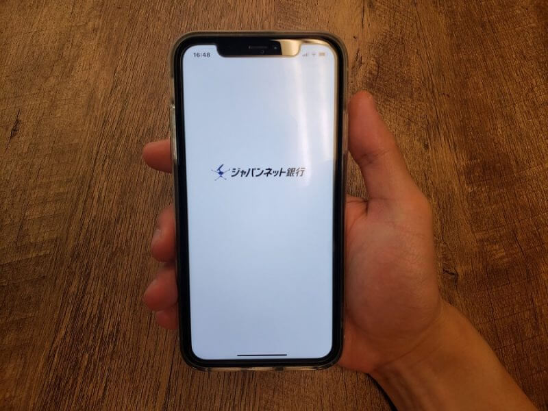 ジャパンネット銀行のアプリ画面を表示するスマートフォン