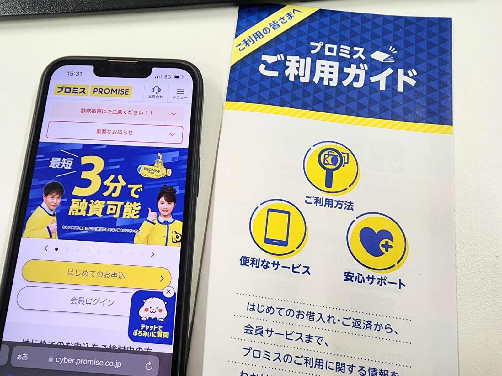 プロミス公式サイトを表示したスマホとプロミスのパンフレット